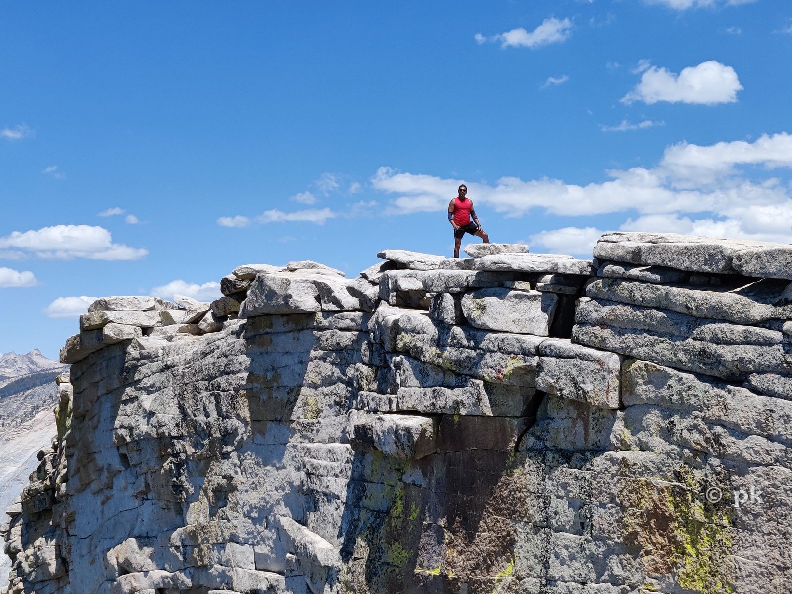 Prateek standing atop a granite rock formation on a hike