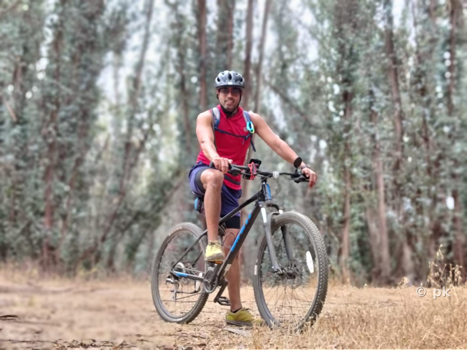 Prateek mountain biking on a wooded trail