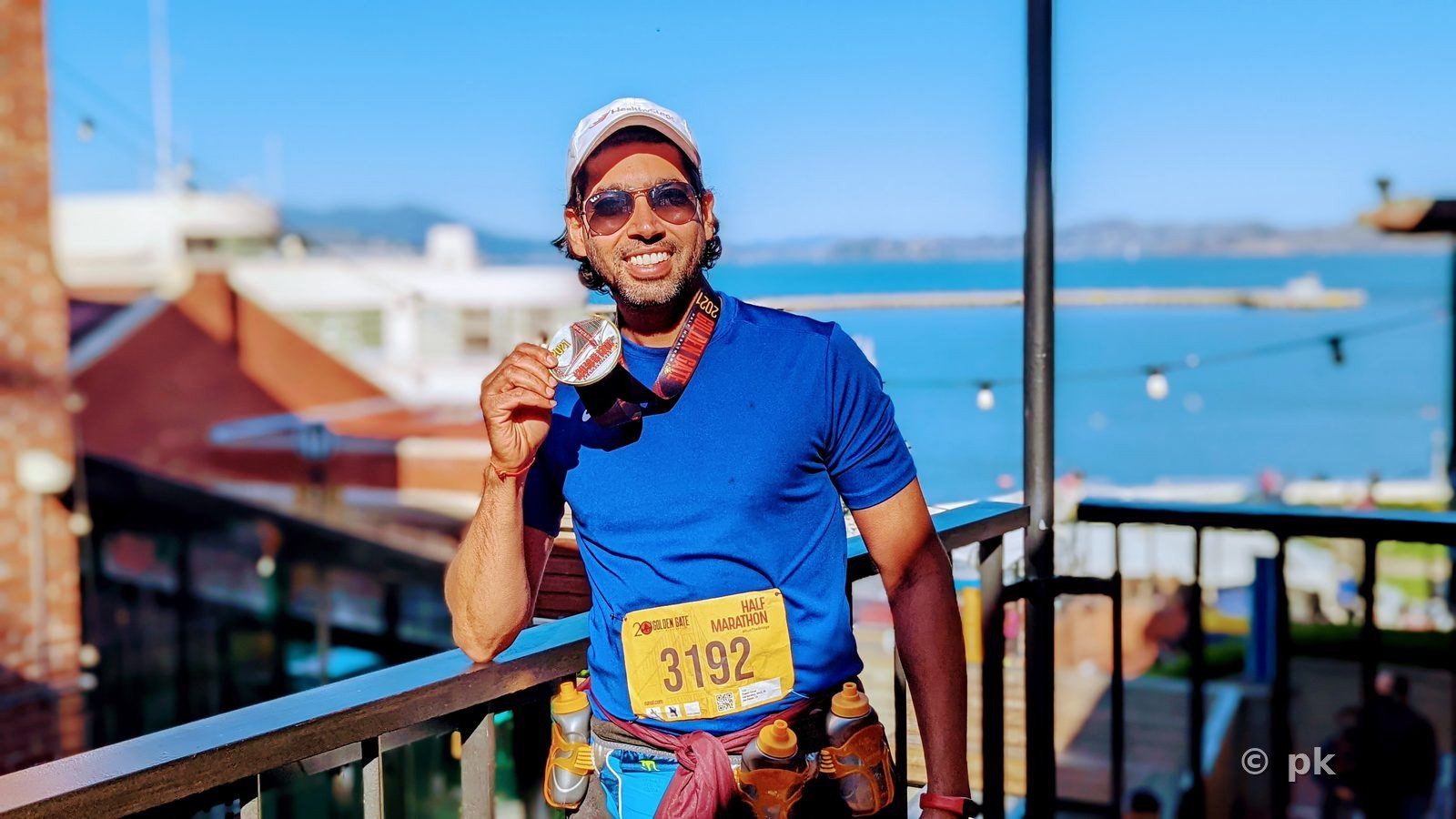 Prateek holding a finisher's medal after a half marathon