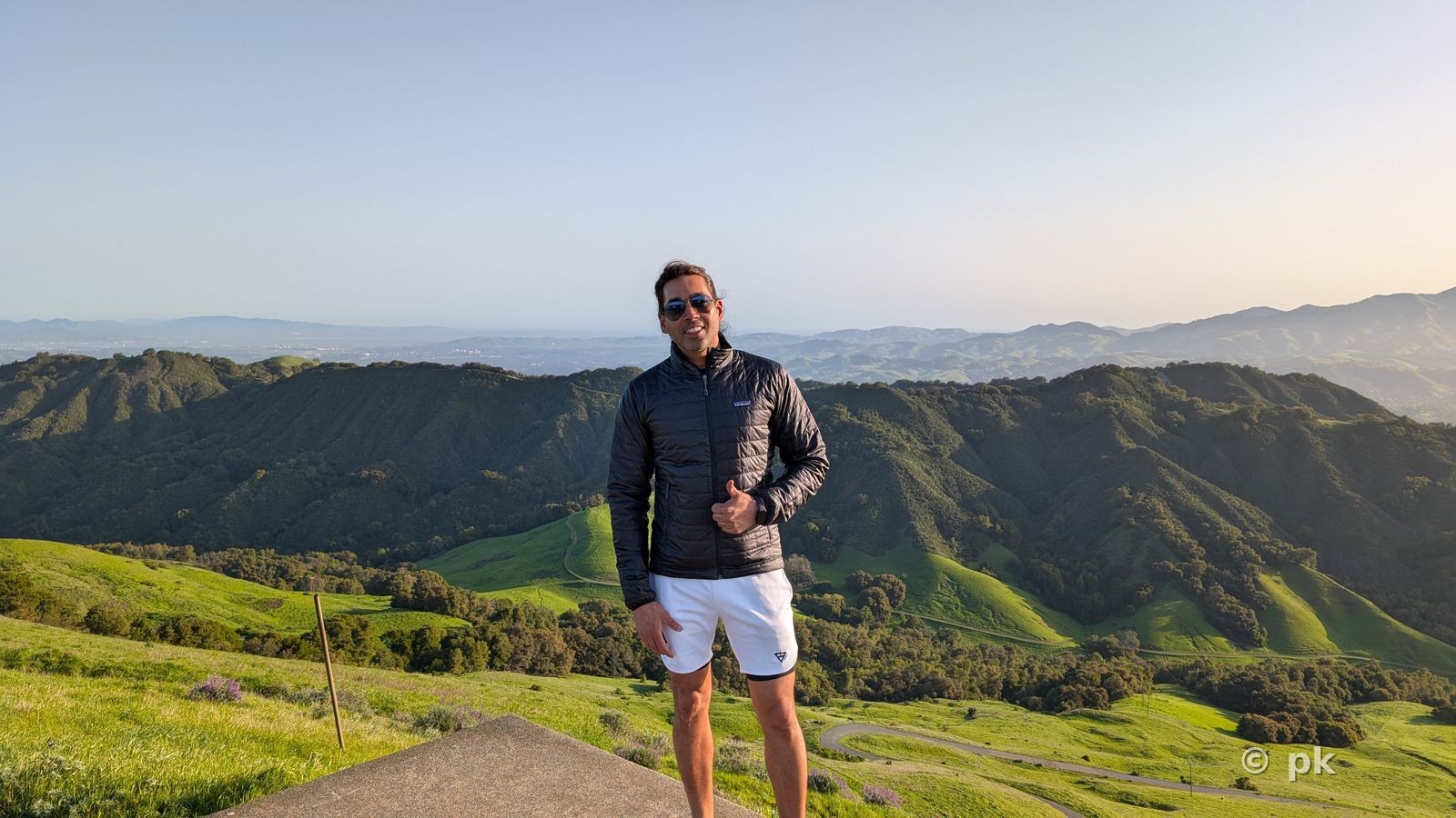 Prateek standing on a scenic overlook above green rolling hills